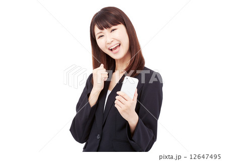 スマートフォンを持って喜ぶビジネスウーマン スマートフォンを持って喜ぶビジネスウーマン 12647495