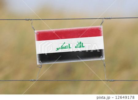 Border fence - Old plastic sign with a flag Border fence - Old plastic sign with a flag 12649178