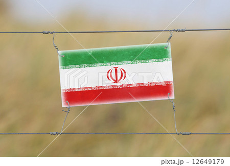 Border fence - Old plastic sign with a flag Border fence - Old plastic sign with a flag 12649179