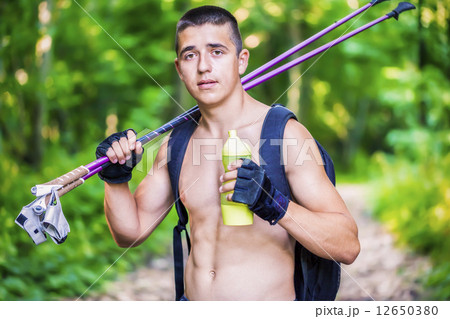 Teenager with water bottle and walking sticks  12650380