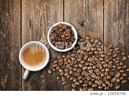 Coffee cups full of fresh espresso and beans on wooden table 12650740
