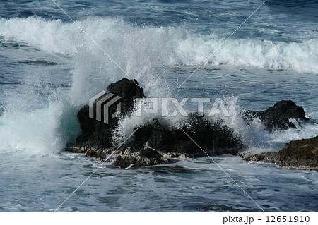 打ち寄せる波と岩に当たって砕ける白波の写真素材