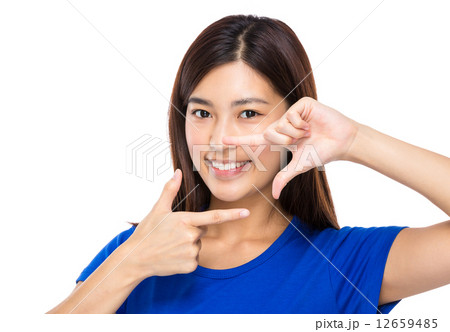 Asian woman with two finger frame in front of mouth 12659485