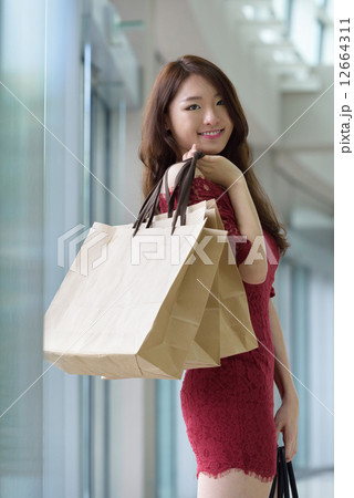 One young pretty woman in red with shopping bags inside the mall One young pretty woman in red with shopping bags inside the mall 12664311