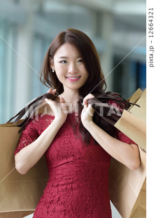 One young pretty woman in red with shopping bags inside the mall One young pretty woman in red with shopping bags inside the mall 12664321