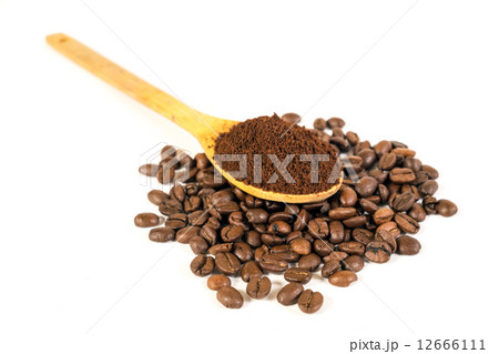 Ground coffee on wooden spoon. Lots of coffee beans scattered on Ground coffee on wooden spoon. Lots of coffee beans scattered on 12666111