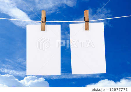 Paper hanging in blue sky background Paper hanging in blue sky background 12677771