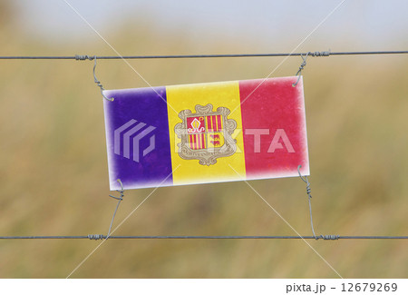 Border fence - Old plastic sign with a flag Border fence - Old plastic sign with a flag 12679269