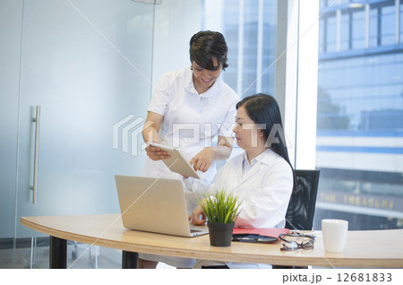 Asian medical team going through a diagnostic report. Asian medical team going through a diagnostic report. 12681833