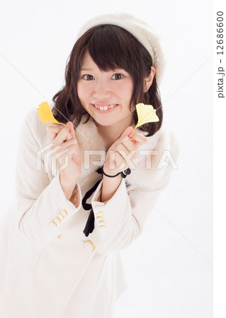 真っ白な冬服を着て銀杏の葉を持つ可愛らしい女の子の写真素材 真っ白な冬服を着て銀杏の葉を持つ可愛らしい女の子の写真素材