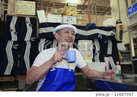 休憩時間にくつろぐ鮮魚店の男性店員 12687097