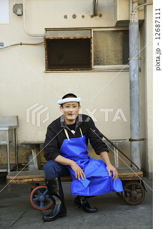 台車の前でポーズをとる鮮魚店の男性店員 台車の前でポーズをとる鮮魚店の男性店員 12687111