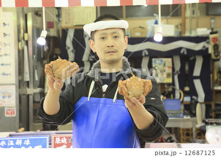 カニを持って立つ鮮魚店の男性店員 カニを持って立つ鮮魚店の男性店員 12687125