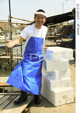 屋外で魚を売る鮮魚店店員の写真素材