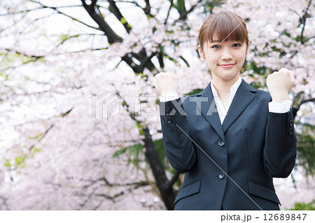 桜の前のスーツ姿の女性 12689847