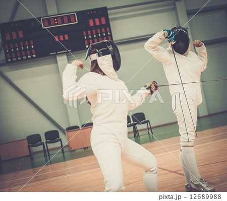 Two women fencers on a training 12689988