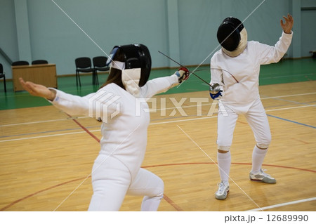 Two women fencers on a training 12689990