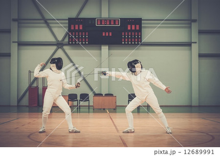 Two women fencers on a training 12689991