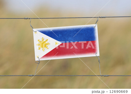 Border fence - Old plastic sign with a flag 12690669