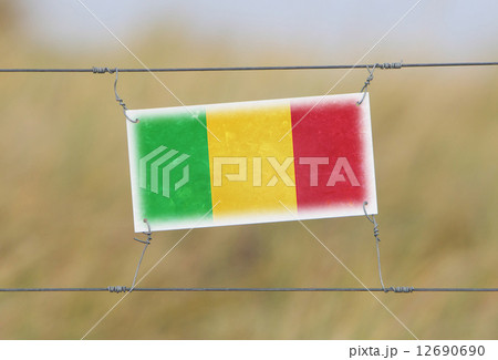 Border fence - Old plastic sign with a flag Border fence - Old plastic sign with a flag 12690690