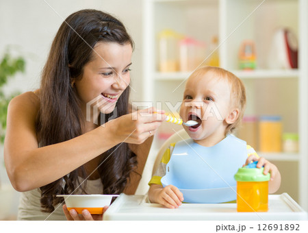 Mum spoon feeding child son Mum spoon feeding child son 12691892
