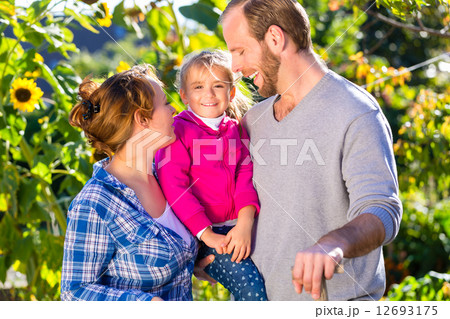 Family gardening, standing with fork in garden 12693175