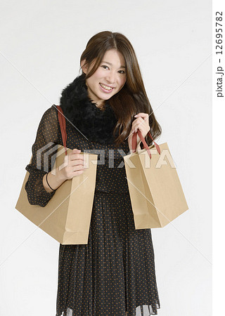 沢山の買い物袋を持つ若い女性 12695782
