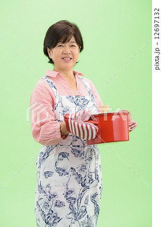 クロマキーを利用した切り抜きのためのポーズ素材ーシニア女性の料理イメージの写真素材