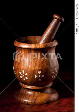 Wooden mortar and pestle on dark Wooden mortar and pestle on dark 12698589