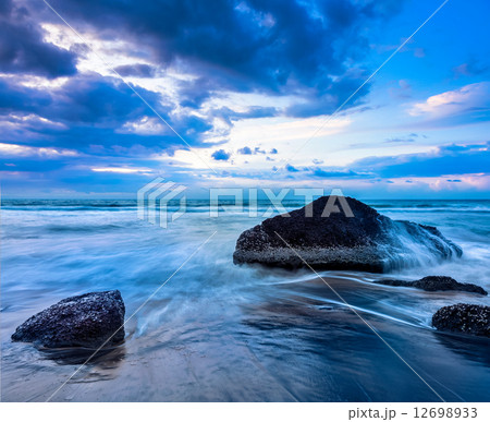 Waves and rocks on beach of sunset 12698933