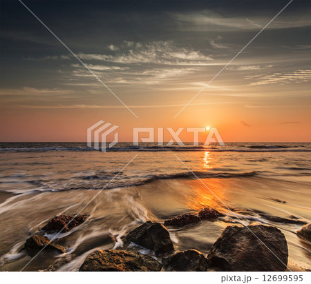Waves and rocks on beach of sunset 12699595