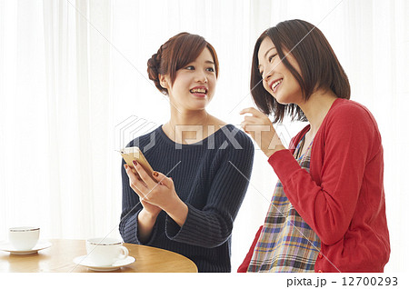 お茶する女子2人で携帯電話 お茶する女子2人で携帯電話 12700293