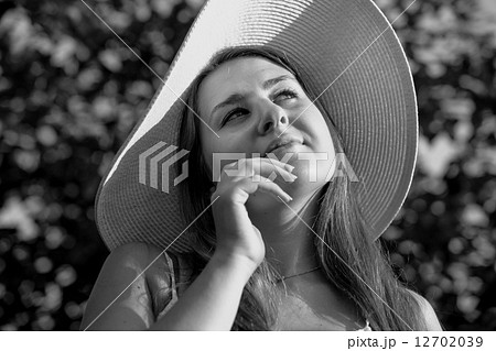 Monochrome portrait of elegant woman in white hat posing at gard Monochrome portrait of elegant woman in white hat posing at gard 12702039