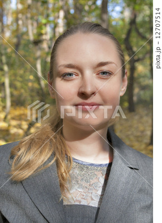 pretty young woman in a gray business dress standing 12707514