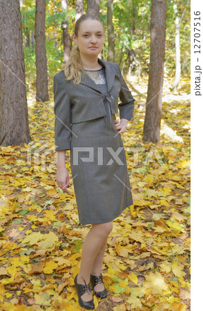 pretty young woman in a gray business dress standing 12707516