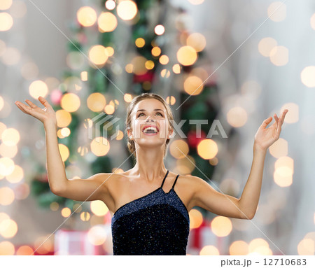 smiling woman raising hands and looking up smiling woman raising hands and looking up 12710683