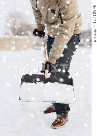 closeup of man digging snow with shovel 12710940