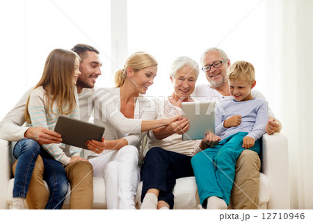 smiling family with tablet pc at home 12710946
