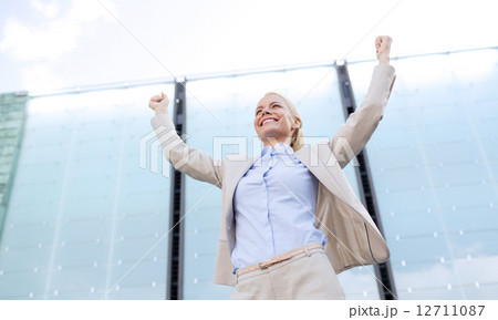 young smiling businesswoman over office building 12711087