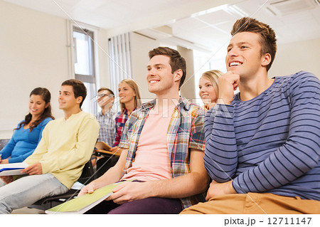 group of smiling students in lecture hall 12711147