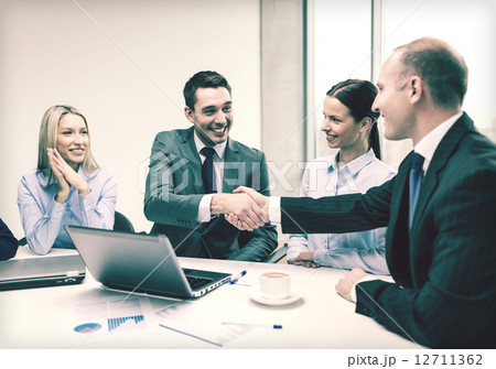 two businessman shaking hands in office 12711362