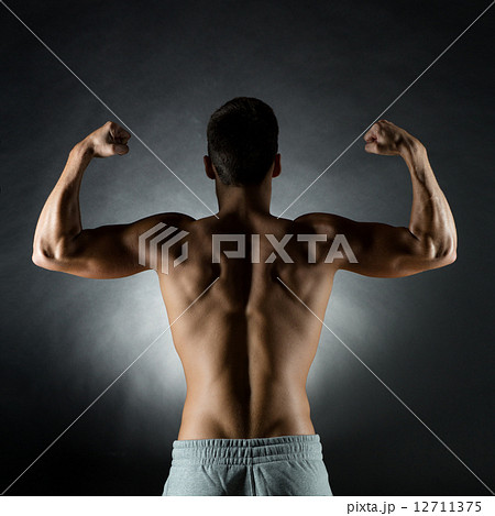 young man showing biceps young man showing biceps 12711375