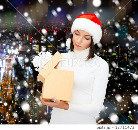 woman in santa helper hat with gift box woman in santa helper hat with gift box 12711472