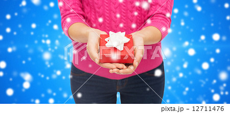 close up of woman in pink sweater holding gift box close up of woman in pink sweater holding gift box 12711476
