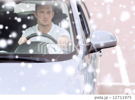 man driving car and putting parking clock 12711975