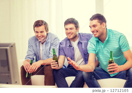 happy male friends with beer watching tv at home 12712105