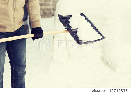 closeup of man shoveling snow from driveway 12712333