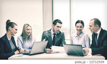 business team with laptop having discussion 12712504