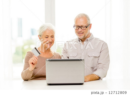 happy senior couple with laptop and credit card happy senior couple with laptop and credit card 12712809