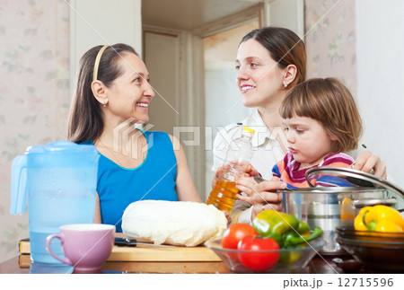 women with child cook vegetables women with child cook vegetables 12715596